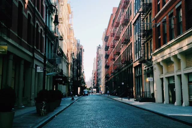 Cobbled city street between brick buildings, upscaled