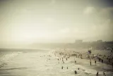 Hazy beach with swimmers in the surf, waiting in the queue